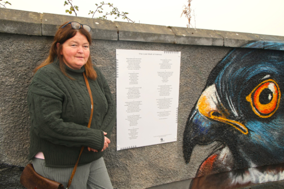 Artist Irene Naughton with her poem and mural 