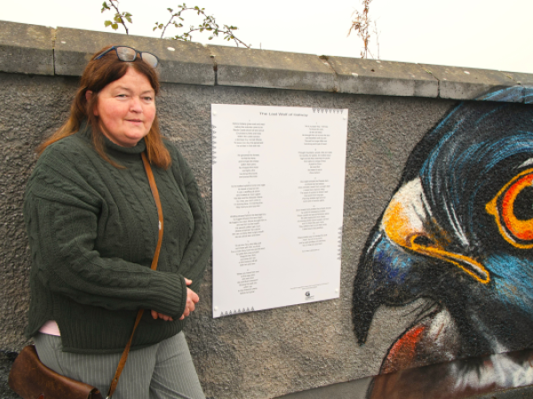 Artist Irene Naughton with her poem and mural 